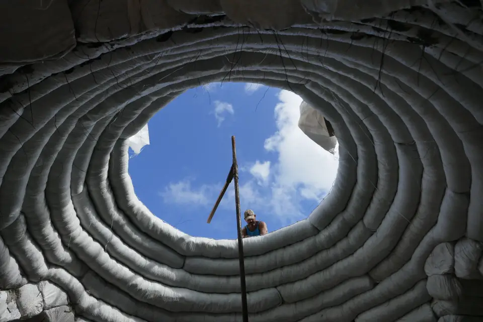 Looking up through rings of earthbags at a round opening and blue sky